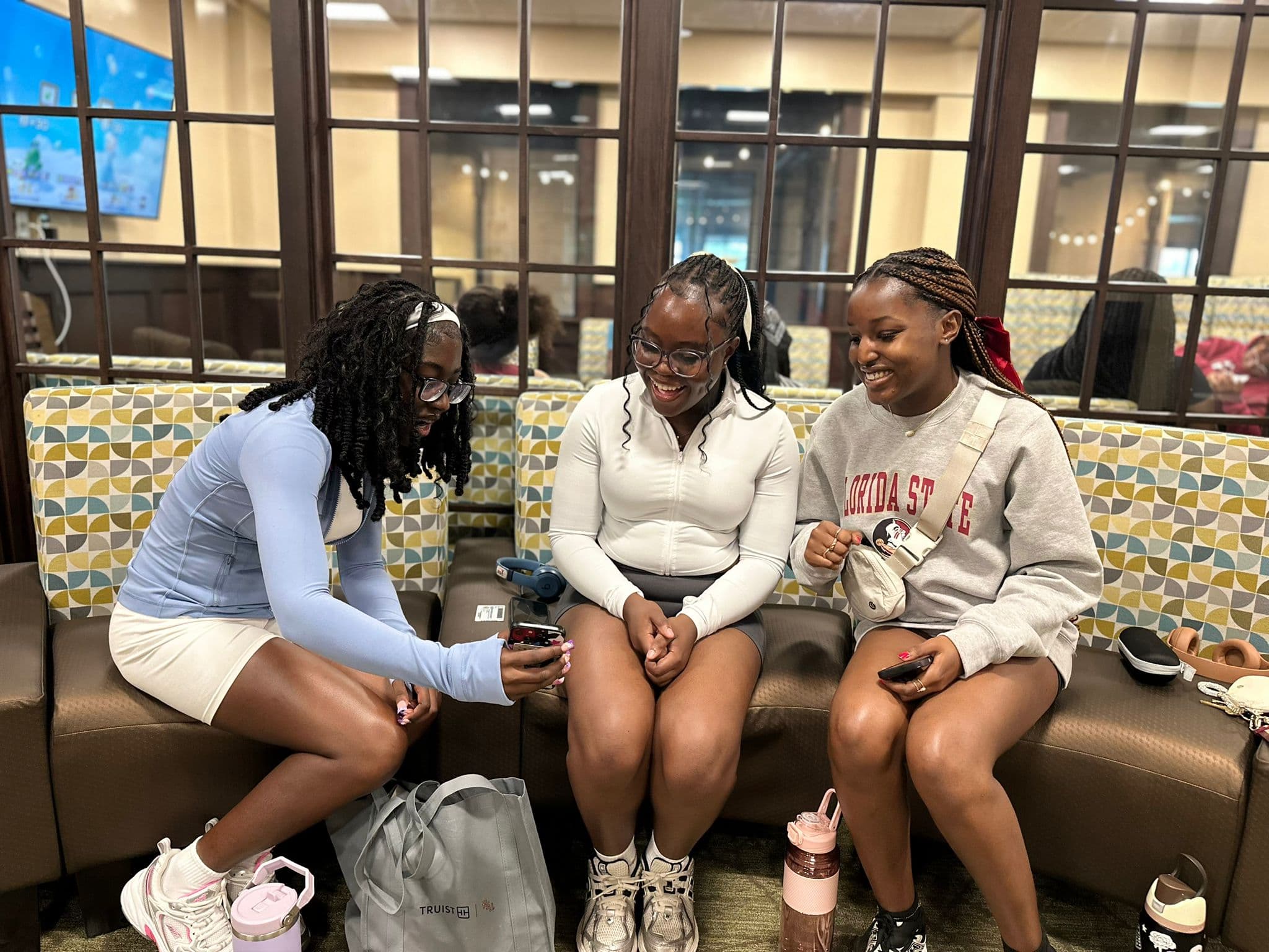 Students sitting together on campus using phones